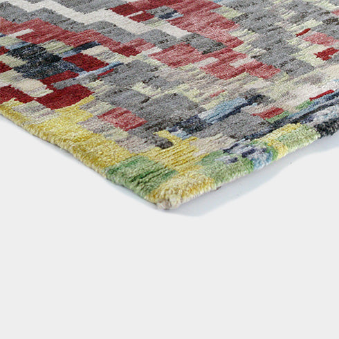 Close-up of the hand-knotted wool and viscose blend showcasing the intricate multicolour pattern.