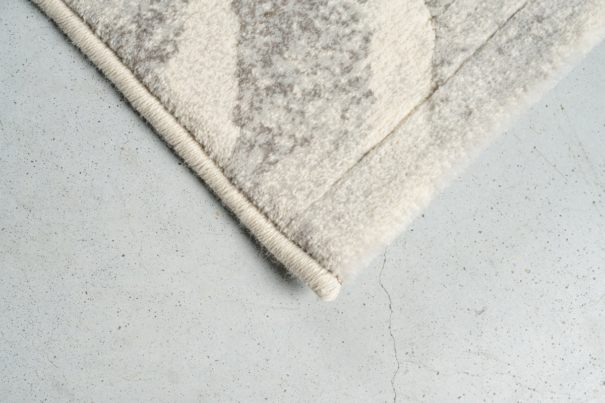 Corner detail of the Tapison Home Torino 063.0990.6797 rug in ivory and pale grey