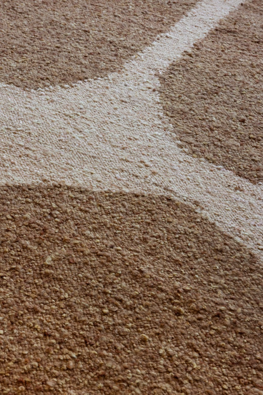 Close-up of caramel wool, jute, and cotton blend in handwoven plaited texture