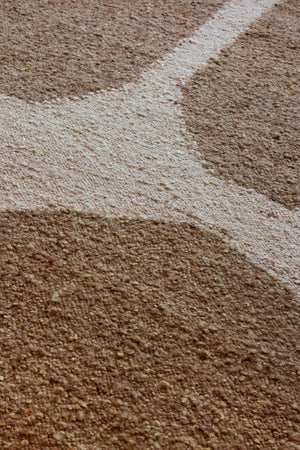 Close-up of caramel wool, jute, and cotton blend in handwoven plaited texture
