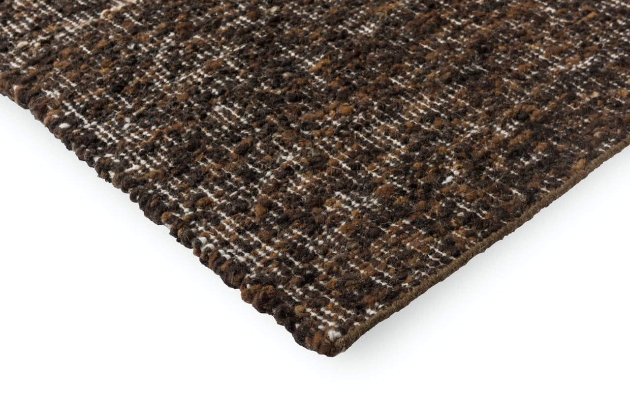 Edge view of sculptural wool rug with varied height and deep colour contrast