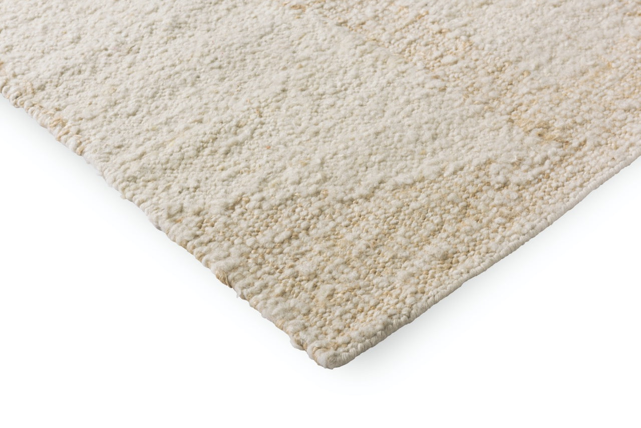 Edge view of Wool White rug with subtle relief and carved geometric form