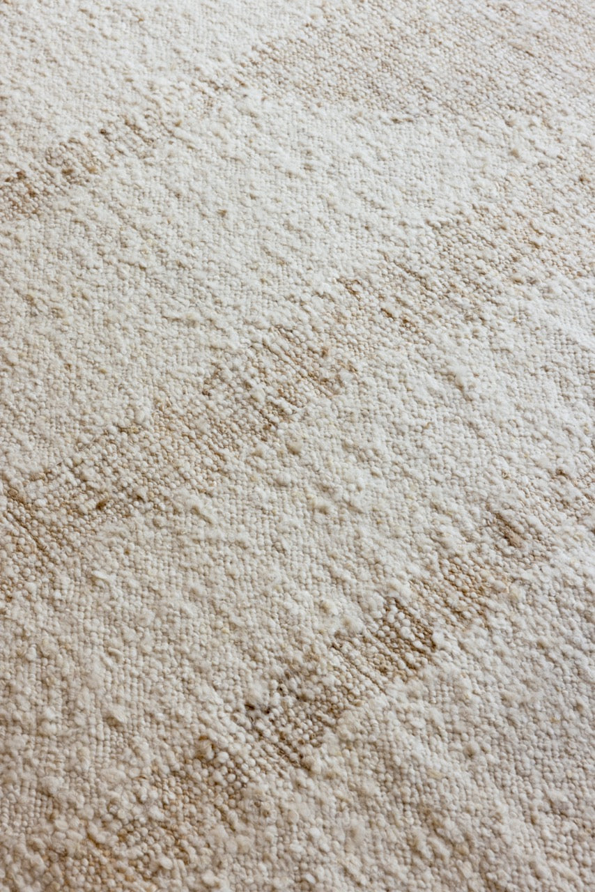 Close-up of sculptural handwoven wool texture in creamy white tones