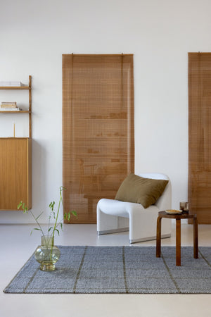 Rug shown under natural wood furniture and earth-toned textiles