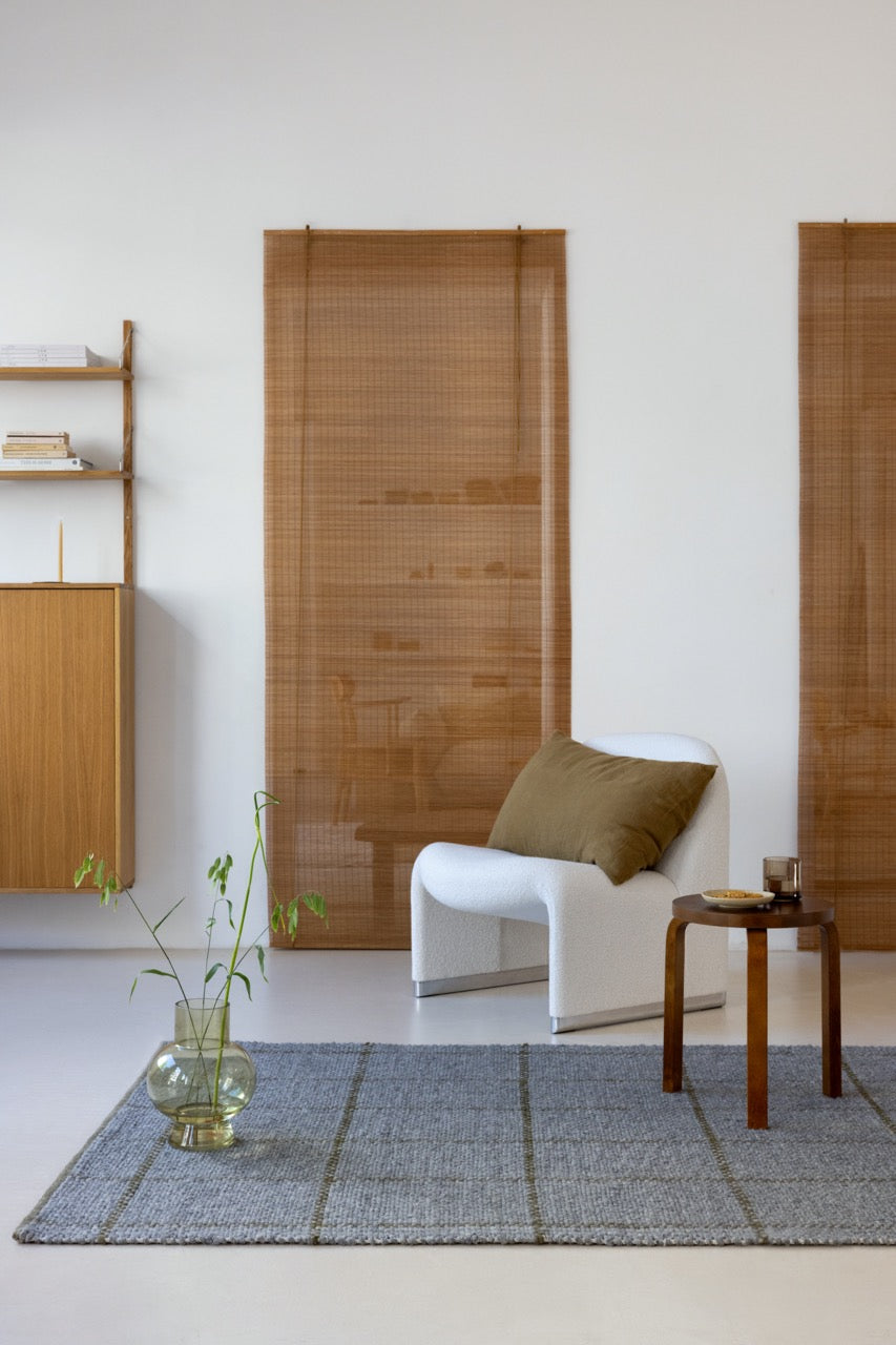 Rug shown under natural wood furniture and earth-toned textiles
