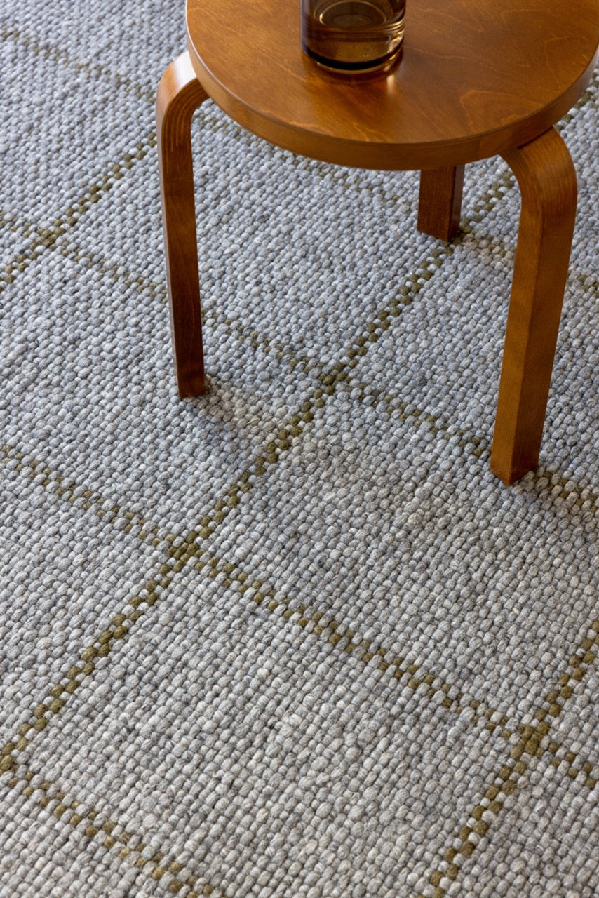 Close-up of flatwoven texture and desaturated colour variation in wool rug