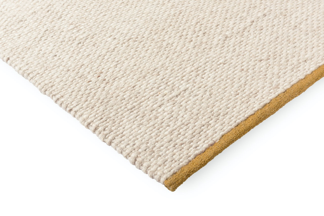 Handwoven wool rug in warm white with flatweave surface detail