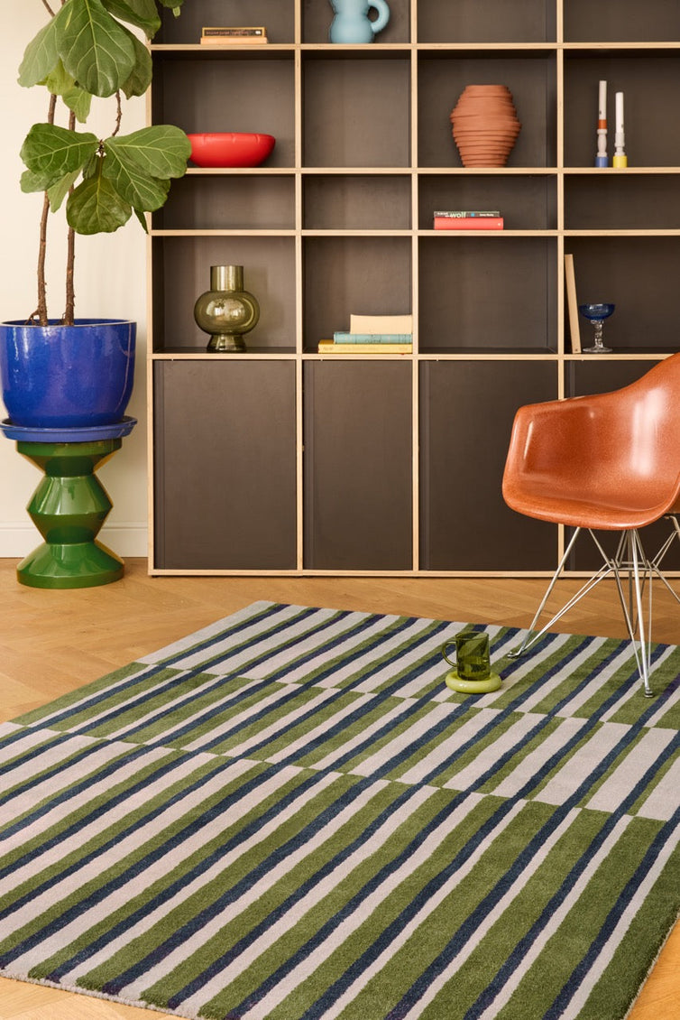 Brink & Campman Decor Pilar Moss rug in moss green with navy blue and light grey stripes, shown in an interior
