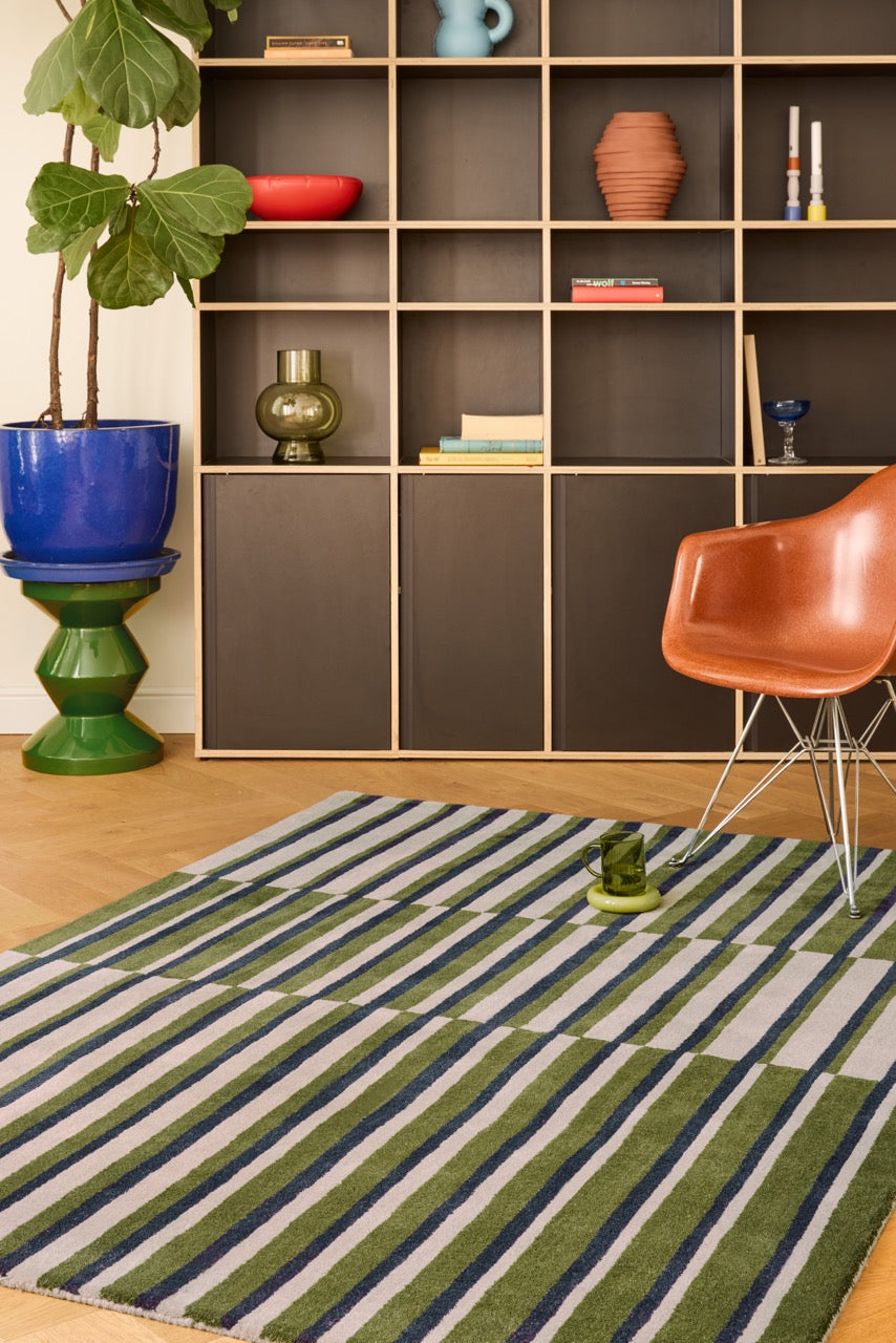 Brink & Campman Decor Pilar Moss rug in moss green with navy blue and light grey stripes, shown in an interior