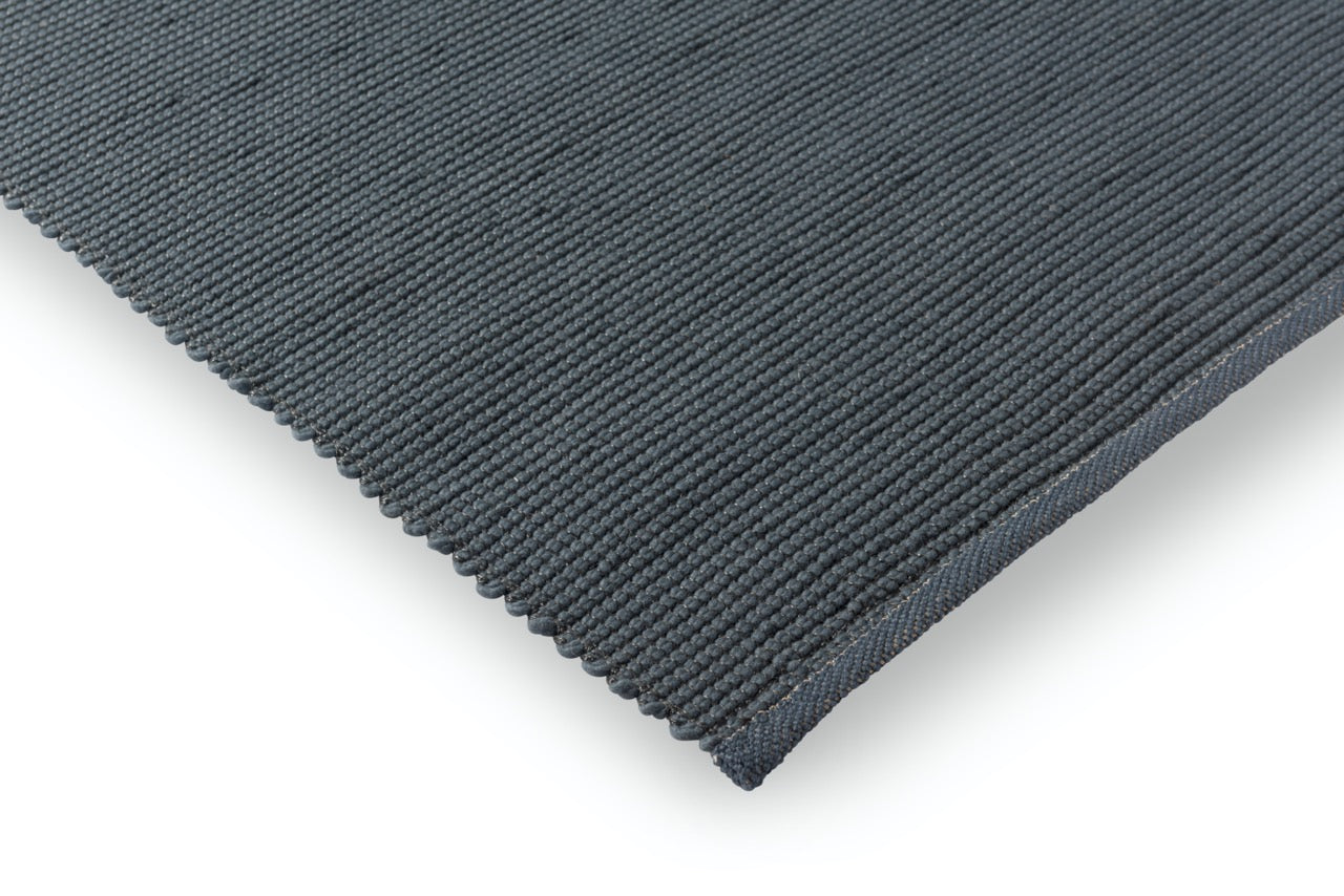 Corner view of flatwoven rug showing weave direction and low profile edge