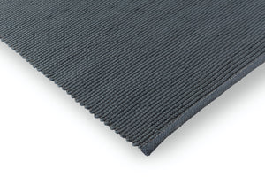 Corner view of flatwoven rug showing weave direction and low profile edge