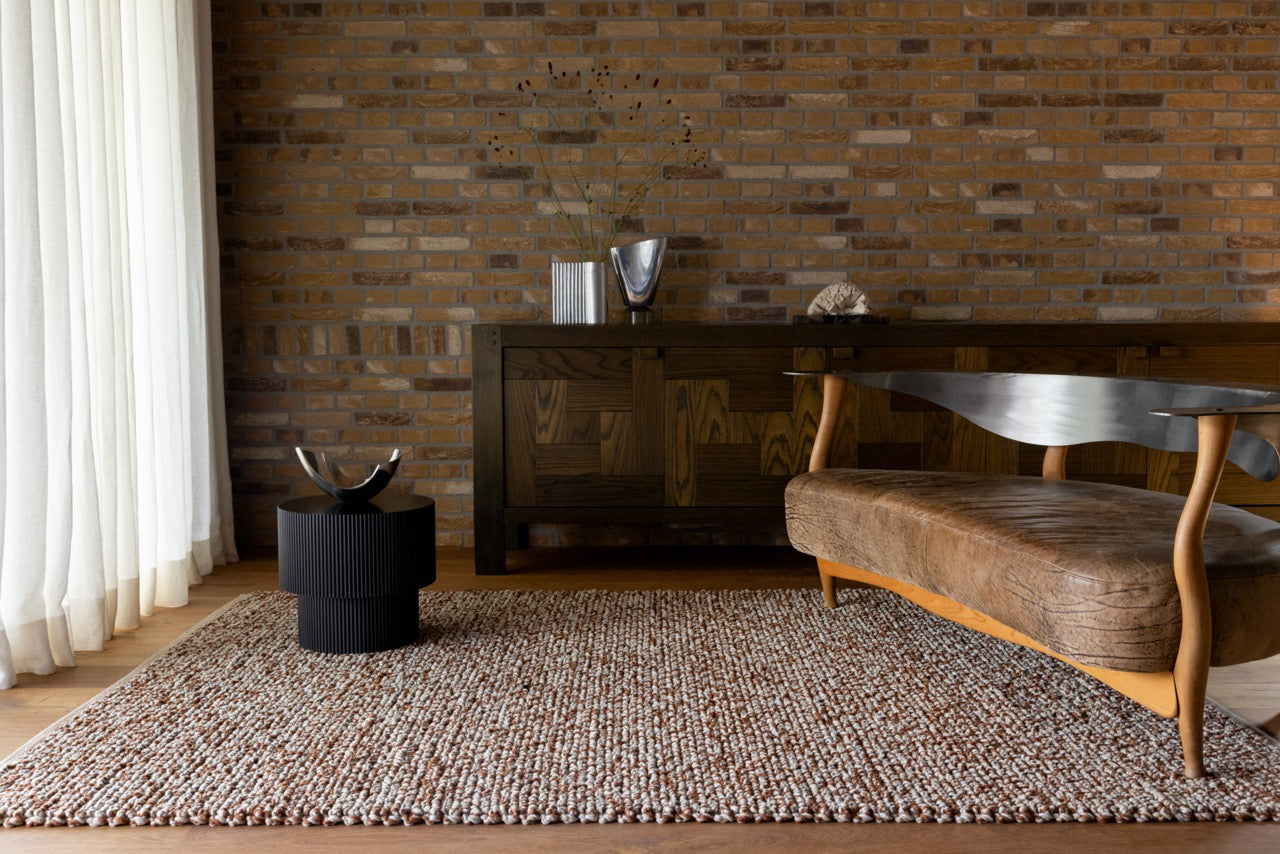 Brink & Campman Nest Leather rug styled in a cozy living room with neutral furnishings and natural accents.