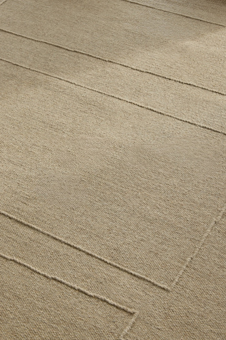Brink & Campman Senso Blocks Natural rug in sand beige with three blocks in relief, shown in an interior, second view