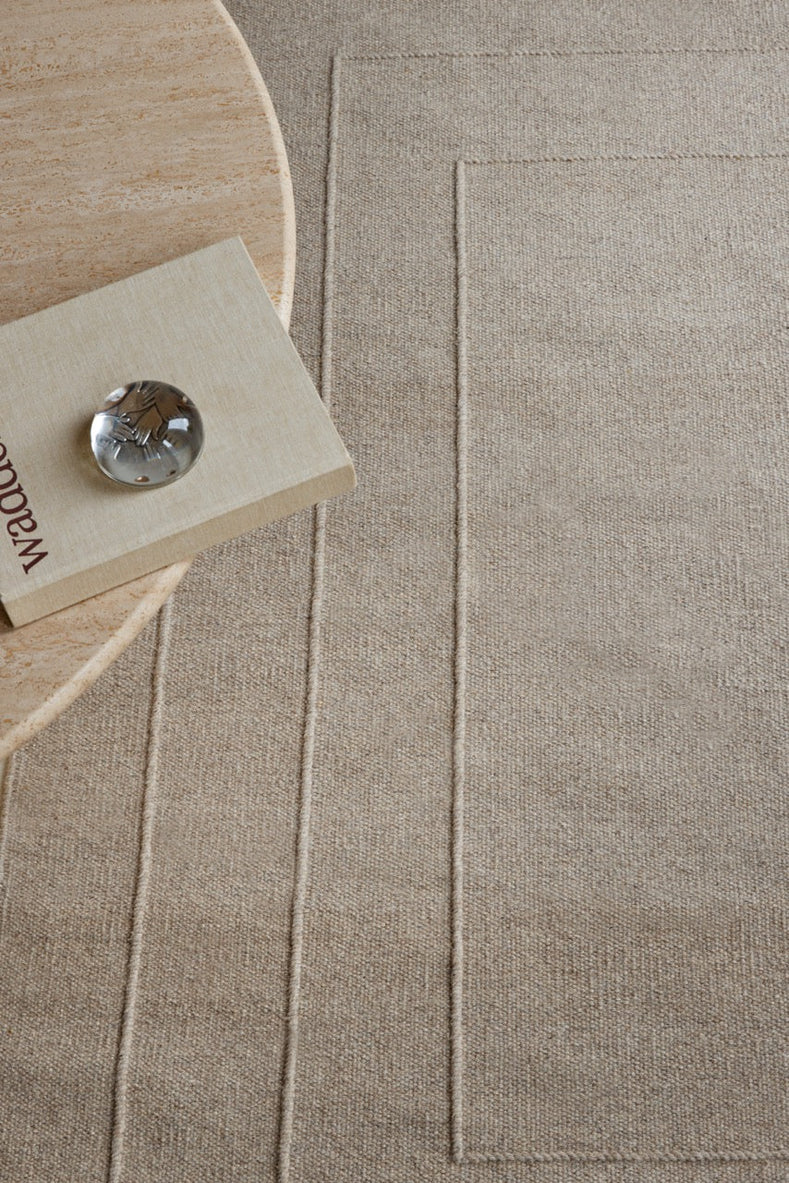 Brink & Campman Senso Border Soft Taupe rug in grey taupe with three frames in relief, shown in an interior, second view