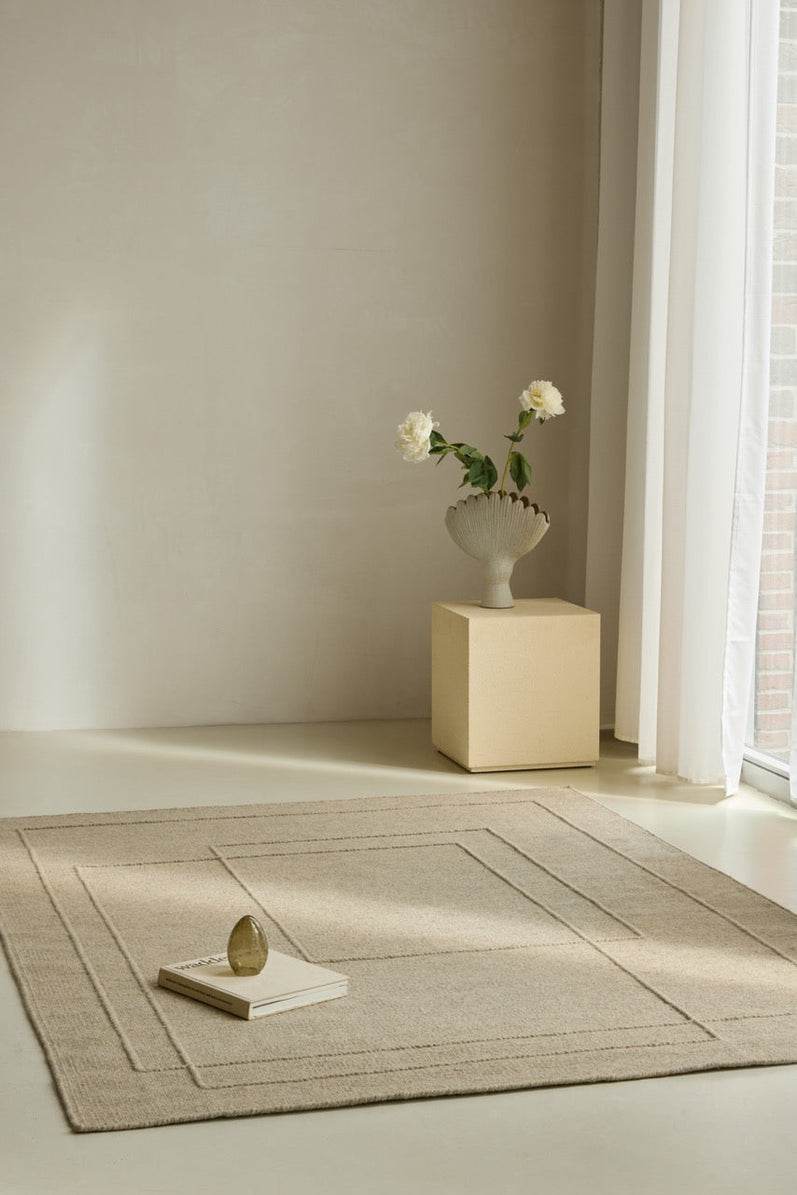 Brink & Campman Senso Planes Natural rug in sand beige with overlapping rectangles in relief, shown in an interior