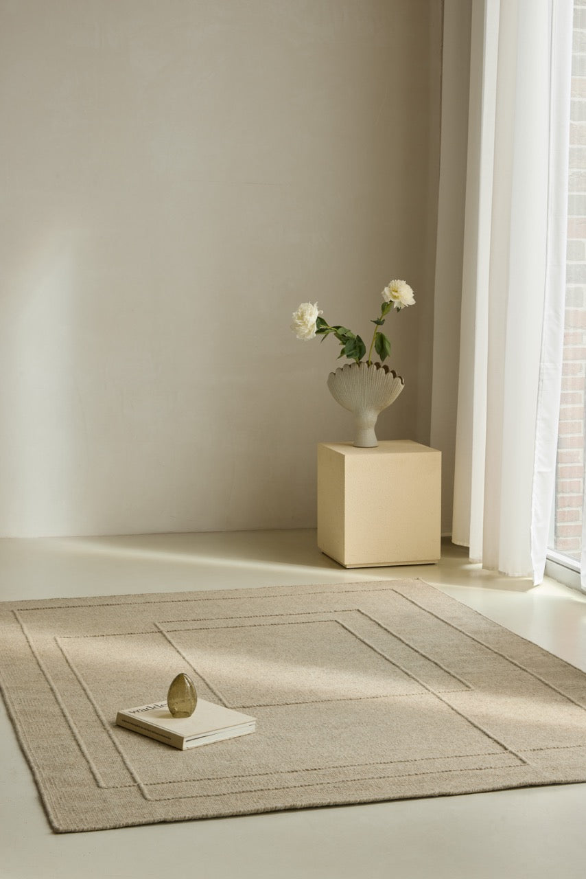 Brink & Campman Senso Planes Natural rug in sand beige with overlapping rectangles in relief, shown in an interior