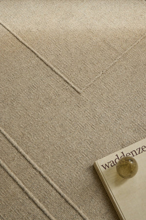 Brink & Campman Senso Planes Natural rug in sand beige with overlapping rectangles in relief, shown in an interior, second view