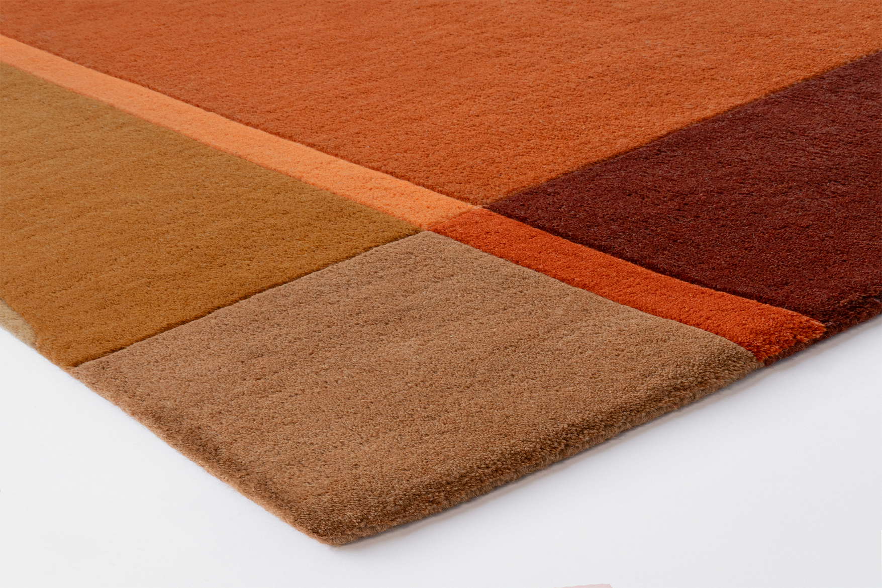 Corner of Acsento Palau Terra rug showing precise tufting, curved design lines, and clean edge

