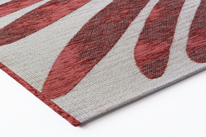 Corner detail of Acsento Salerno Rouge Castille rug showing tight flatwoven edge and striped detailing

