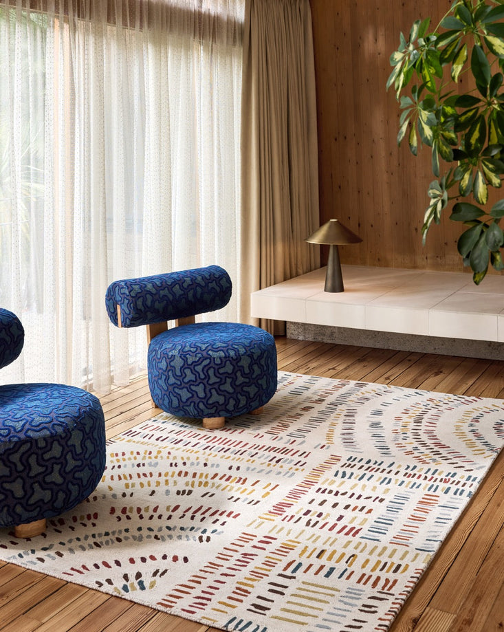 Harlequin Frescoes Amber rug in ivory with dashes in amber, rust and teal, shown in an interior