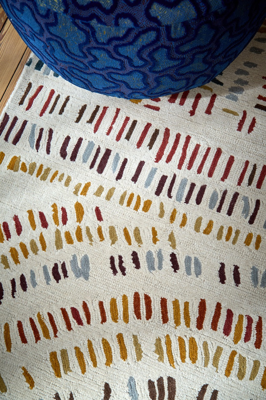 Harlequin Frescoes Amber rug in ivory with dashes in amber, rust and teal, shown in an interior, third view