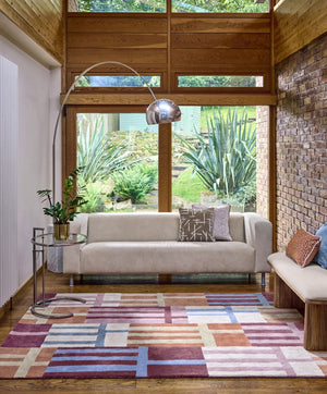 Harlequin Monolith Cinnabar Amber rug in burnt orange, wine red and denim blue, shown in an interior