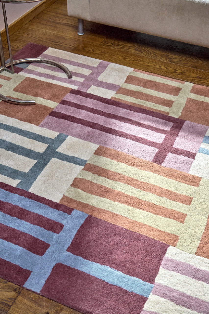 Harlequin Monolith Cinnabar Amber rug in burnt orange, wine red and denim blue, shown in an interior, second view