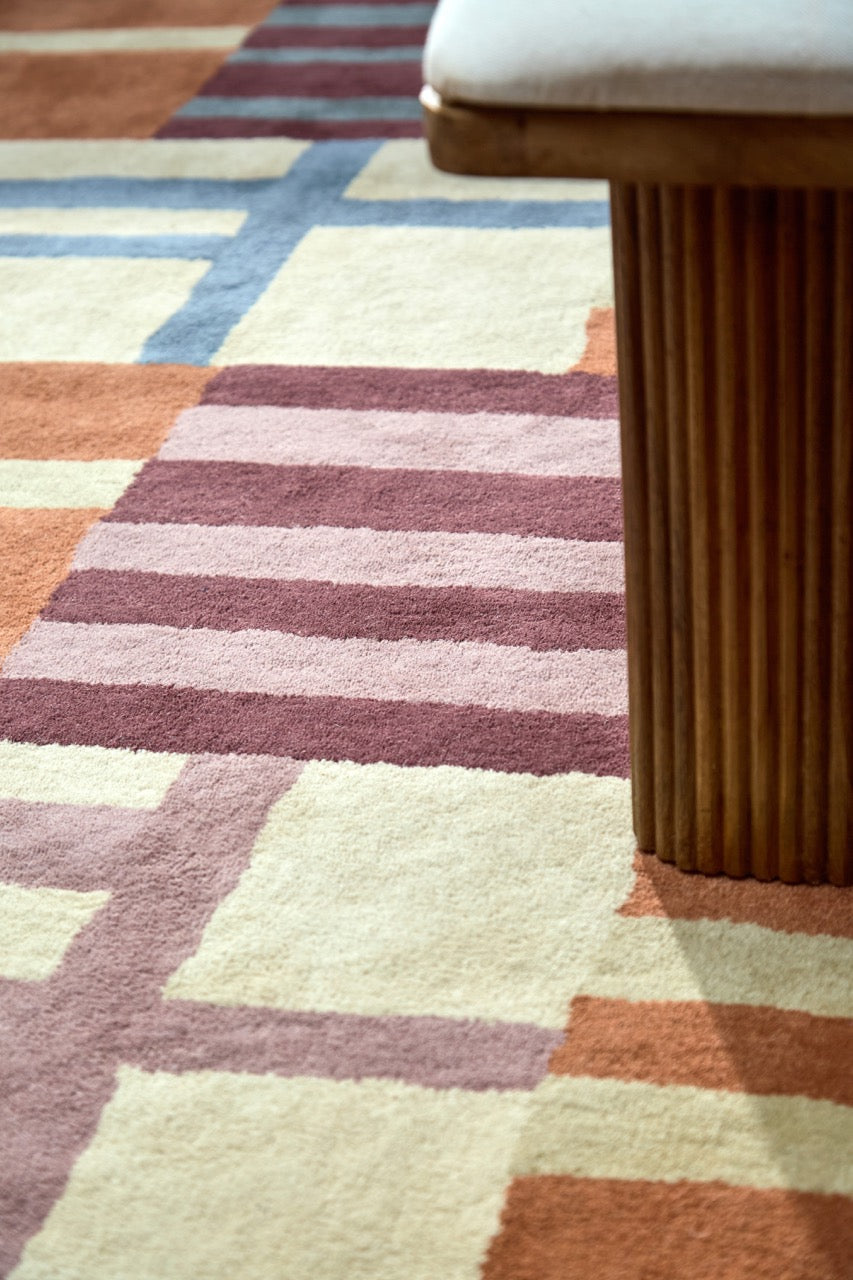 Harlequin Monolith Cinnabar Amber rug in burnt orange, wine red and denim blue, shown in an interior, third view