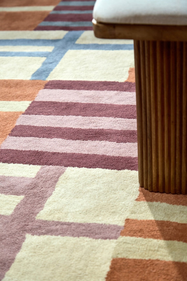 Harlequin Monolith Cinnabar Amber rug in burnt orange, wine red and denim blue, shown in an interior, third view