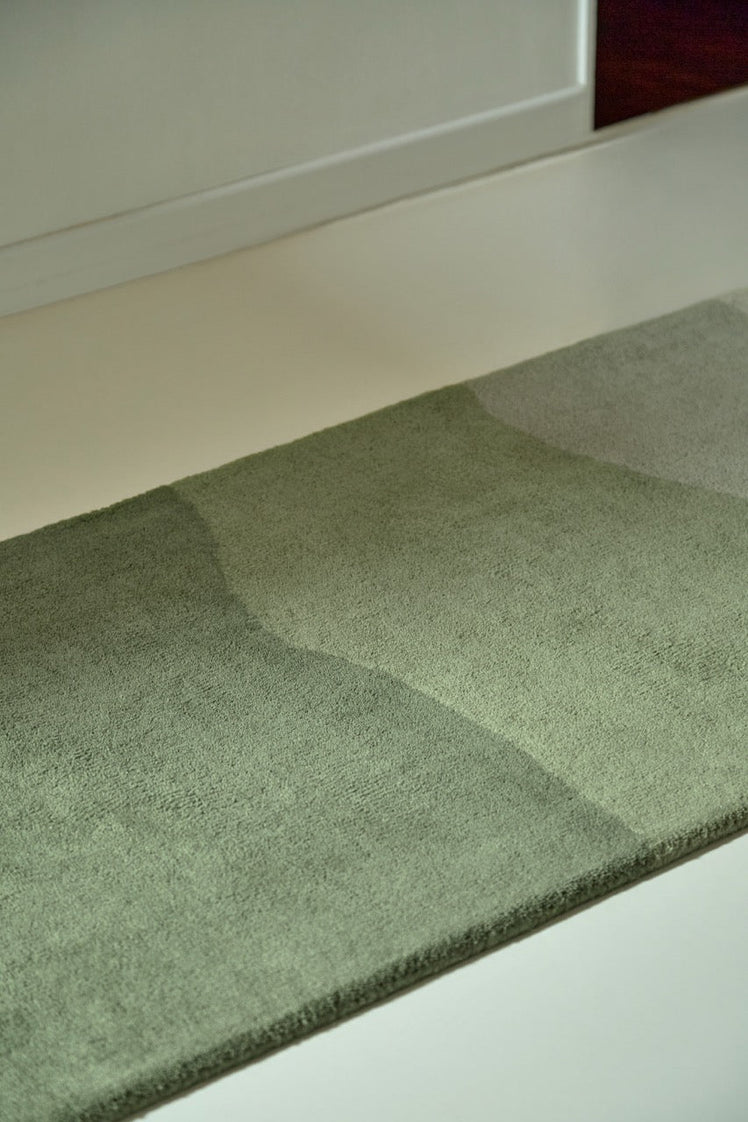 Harlequin Sedimentary Pine runner in pine green and sage, shown in an interior, second view