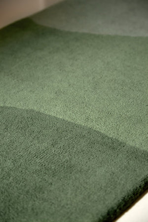 Harlequin Sedimentary Pine runner in pine green and sage, shown in an interior, third view