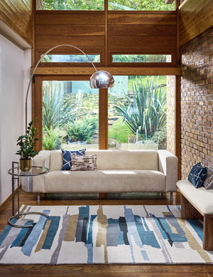 Harlequin Zeal Indigo rug in ivory with blue and ochre brushstrokes, shown in an interior