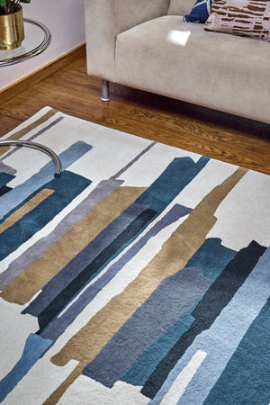 Harlequin Zeal Indigo rug in ivory with blue and ochre brushstrokes, shown in an interior, second view