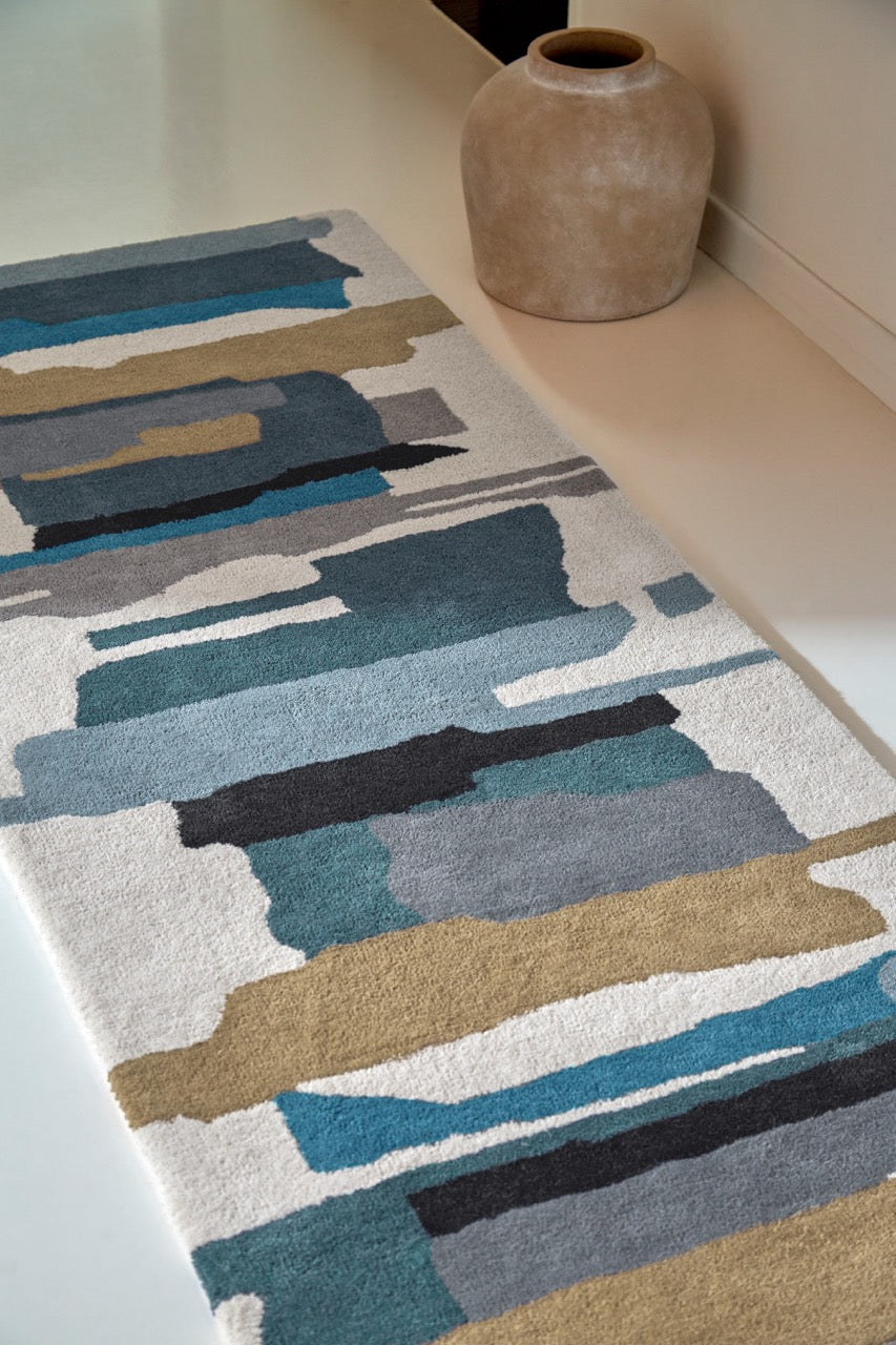Harlequin Zeal Indigo runner in ivory with blue and ochre brushstrokes, shown in an interior