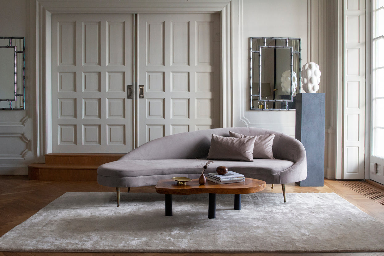 Layered Artisan Plain Bone White rug styled in a pale wood living room with linen and ceramic accents

