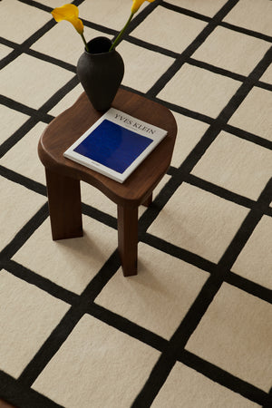 Close-up of the handwoven wool texture showcasing the intricate black-and-white check pattern.

