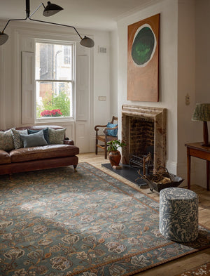 Morris & Co Theodosia Bottle Green rug in bottle green with caramel and ivory flowers, shown in an interior