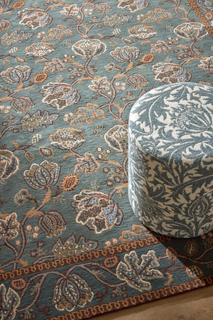 Morris & Co Theodosia Bottle Green rug in bottle green with caramel and ivory flowers, shown in an interior, second view