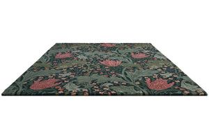 Morris & Co Lent Lily Indigo Madder rug in indigo with madder red tulips and sage leaves, perspective view