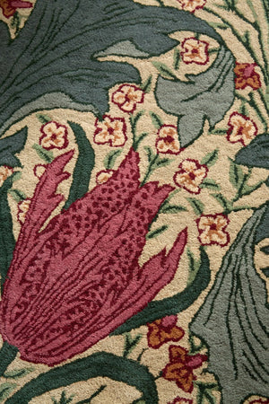 Morris & Co Lent Lily Plum Bayleaf rug in cream with plum tulips and bay green leaves, shown in an interior, third view