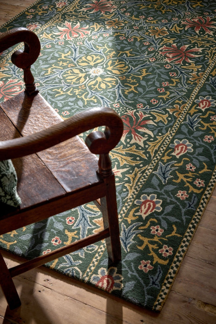 Morris & Co Walthamstow Forest Teal rug in forest green, teal and old gold, shown in an interior, second view