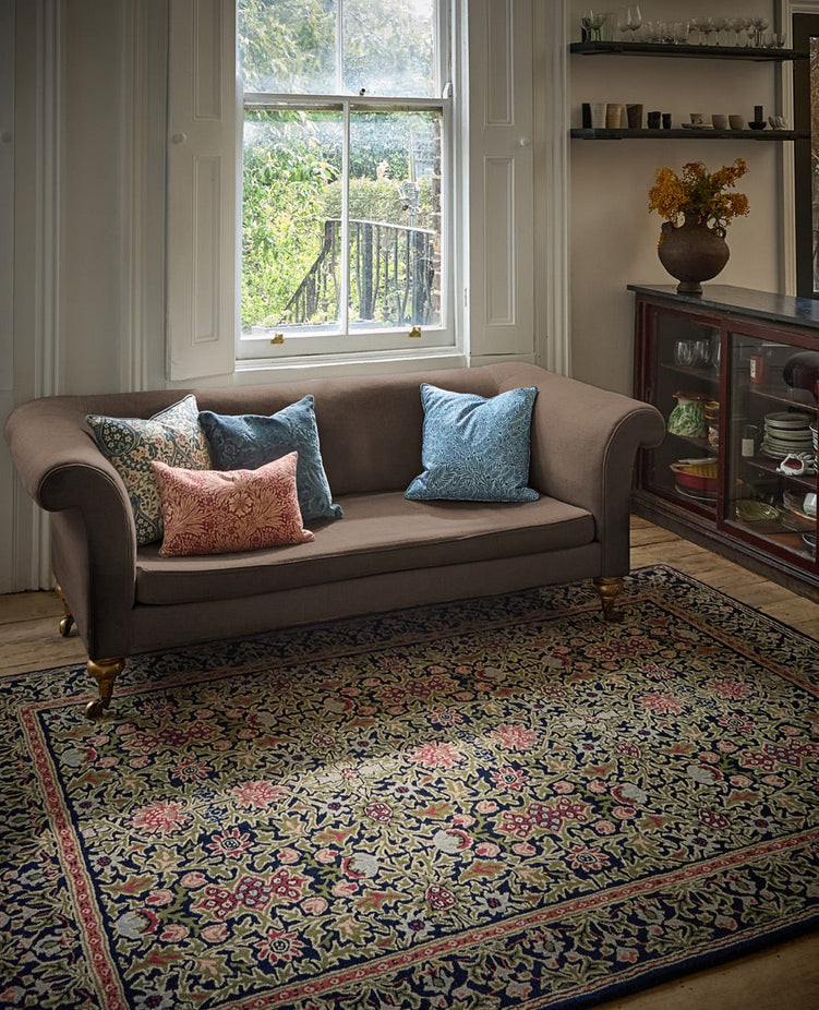 Morris & Co Wilton Weave Indigo rug in indigo, olive green and rose, shown in an interior