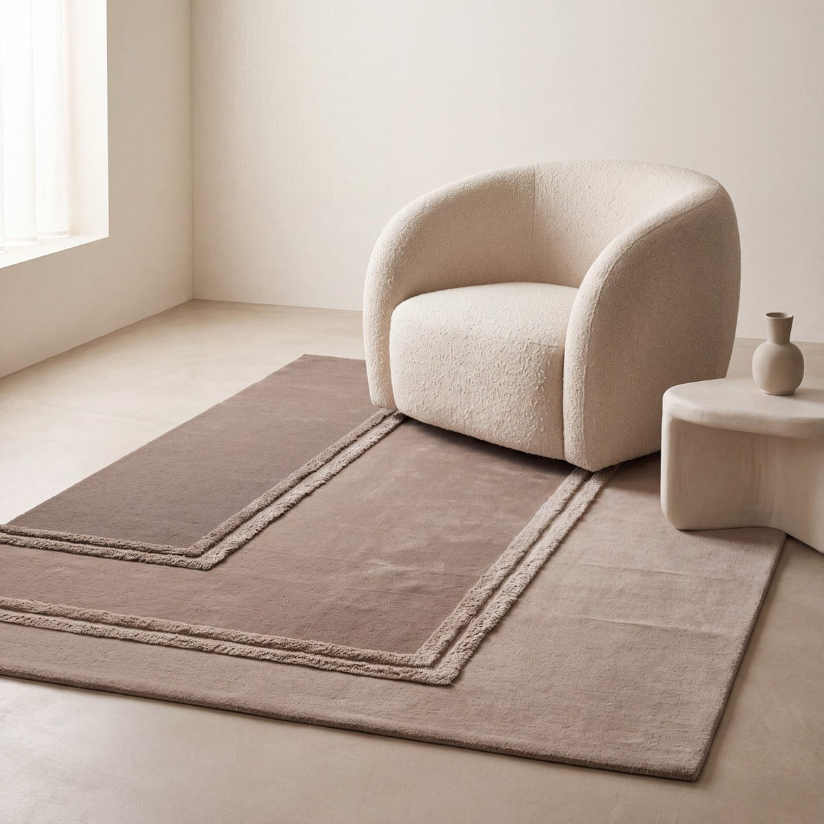 Acsento Delos Beige rug in three beige tones from taupe to sand with raised borders, shown in an interior