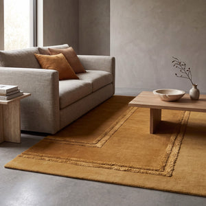 Acsento Delos Mustard rug in mustard yellow and ochre with raised borders, shown in an interior