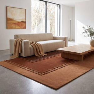 Acsento Delos Rust rug in rust, terracotta and chocolate brown with raised borders, shown in an interior