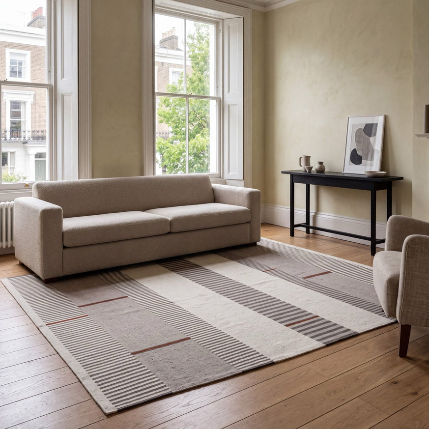 Acsento Oslo Grey Terra rug in grey with ivory and charcoal stripes and terracotta accents, shown in an interior