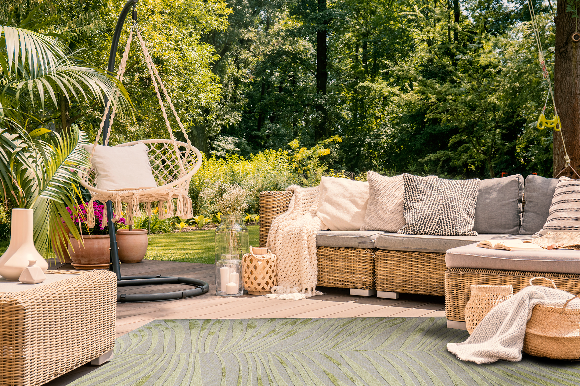 Acsento Salerno Pine green rug styled in a covered garden terrace with light furniture and leafy surroundings