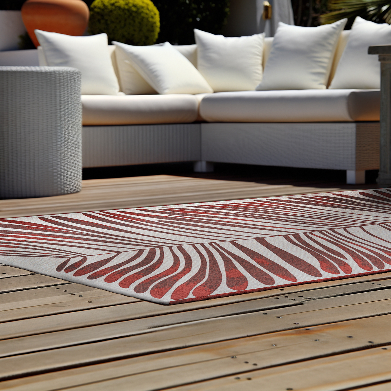 Acsento Salerno Rouge Castille rug styled in a shaded outdoor terrace with lounge furniture

