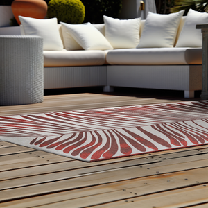 Acsento Salerno Rouge Castille rug styled in a shaded outdoor terrace with lounge furniture

