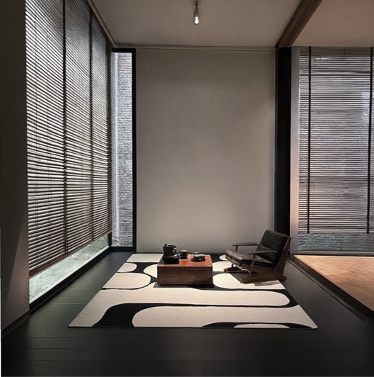 Acsento Swing Black-White rug in black and cream with bold rounded shapes, shown in an interior